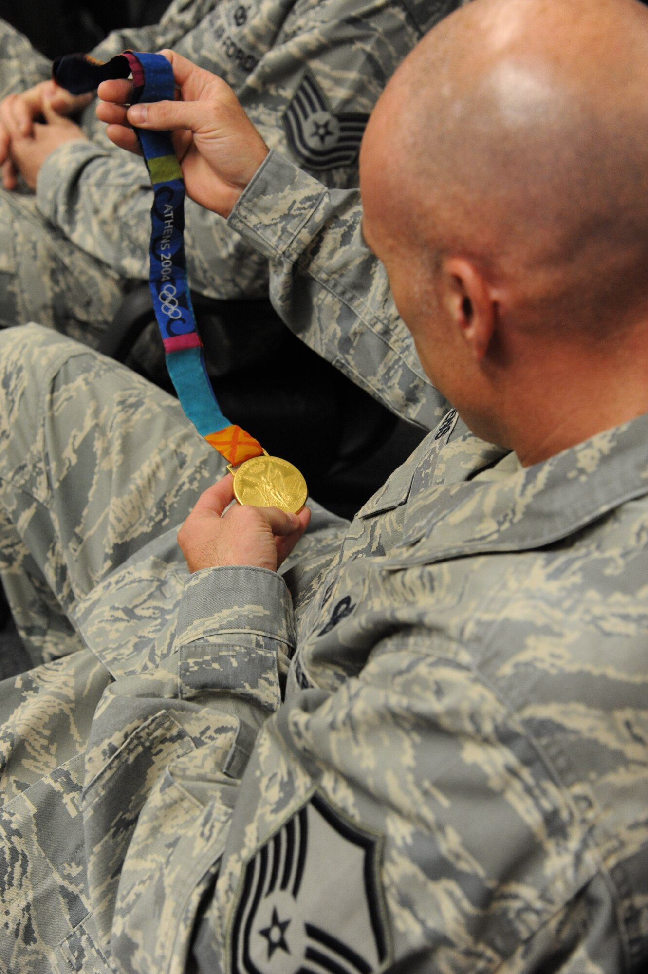 A master sergeant holds an Olympic gold medal won during the 2004 Olympic Games in Athens by Devon Harris, a member of the first Jamaican bobsled team.  The medal has been held by thousands of servicemen, said Powers, and the fact that it has brought joy and inspiration to those people makes it even more special. (U.S. Air Force photo/Airman 1st Class Collin Schmidt)