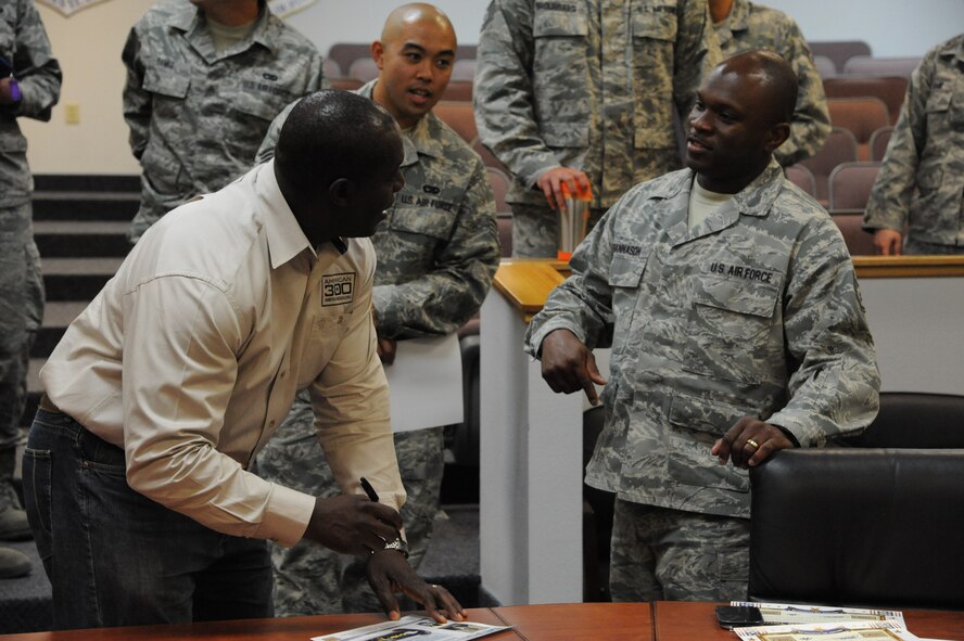 Devon Harris, a retired Jamaican army captain and member of the first Jamaican bobsled team, signs American300 posters for Staff Sgt. Darren Esannason, 341st Logistics Readiness Squadron heavy equipment operator, on June 11 after giving a speech in support of the American300 Keep on Pushing Tour. Harris shared his life story to help encourage the Airmen of the 341st Missile Wing during his time on Malmstrom.  (U.S. Air Force photo/Airman 1st Class Collin Schmidt) 