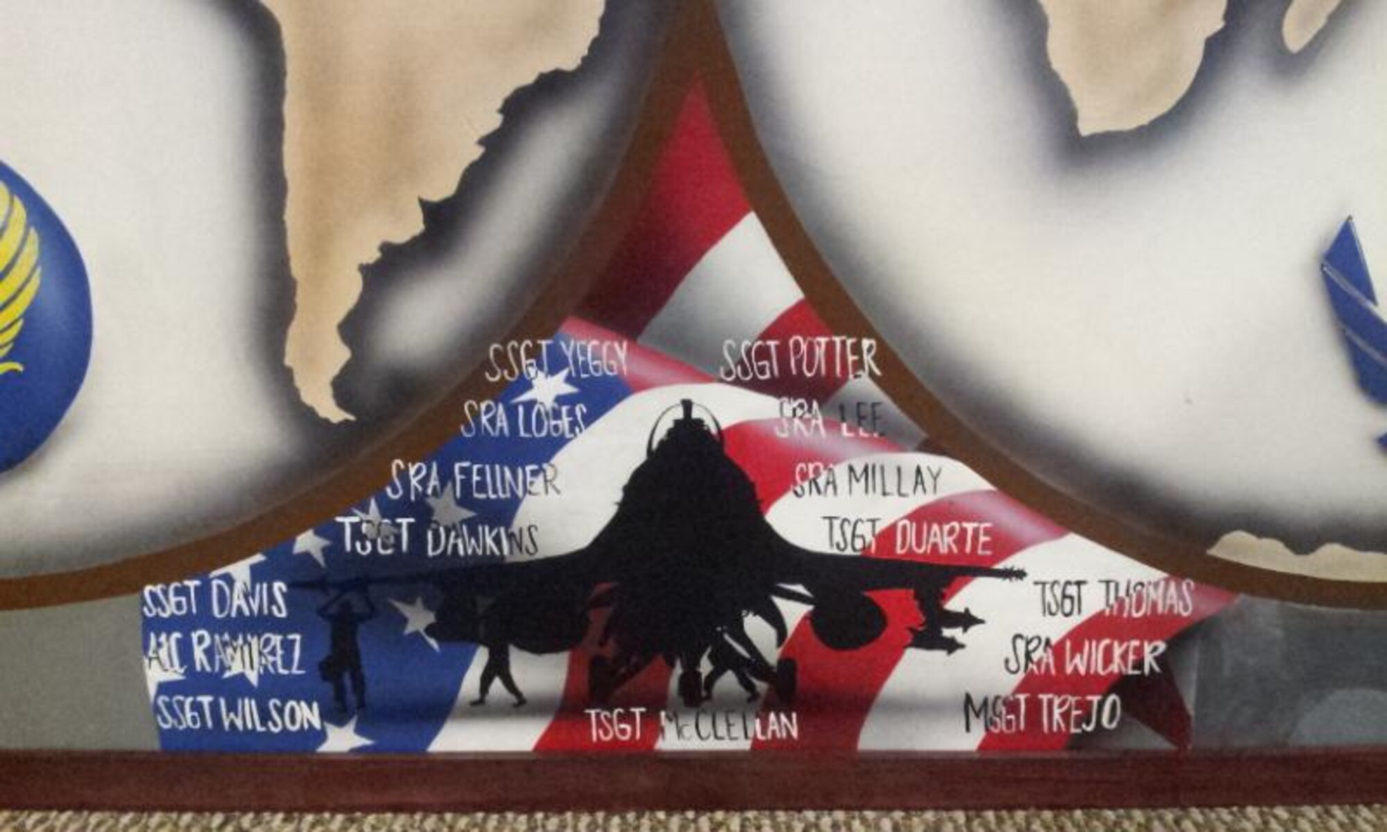 All fifteen of the volunteers who participated in creating the 388th Fighter Wing mural for the Airman Leadership School at Hill Air Force Base, Utah, have their names inscribed around the silhouette of an F-16 in between the two old-fashioned globe maps that play a central role in the mural. (U.S. Air Force photo/Senior Master Sgt. Gary Trejo)