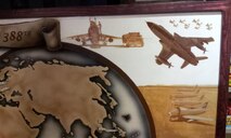 In the far right corner, another period of time is depicted in another type of artistic style, that of a magazine illustrator of a bygone era. The image shows the 388th Fighter Wing's history during a time period — that of the “French flyboy” — when the wing at Hill Air Force Base, Utah, was stationed in England and fighting in World War II. (U.S. Air Force photo/Senior Master Sgt. Gary Trejo)