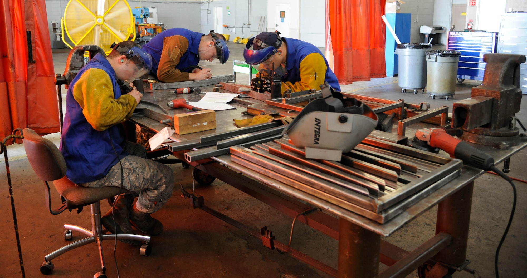 Airmen from the 2nd Maintenance Squadron Fabrication Flight redo the etching of weight limits onto MHU-97E cargo hook adapters on Barksdale Air Force Base, La., June 20, 2013. The weight limit was being lowered from 6,000 pounds to 3950 and had to be properly labeled to avoid over stressing the hooks when used to lift and transport cargo and munitions. (U.S. Air Force photo/Airman 1st Class Andrew Moua)