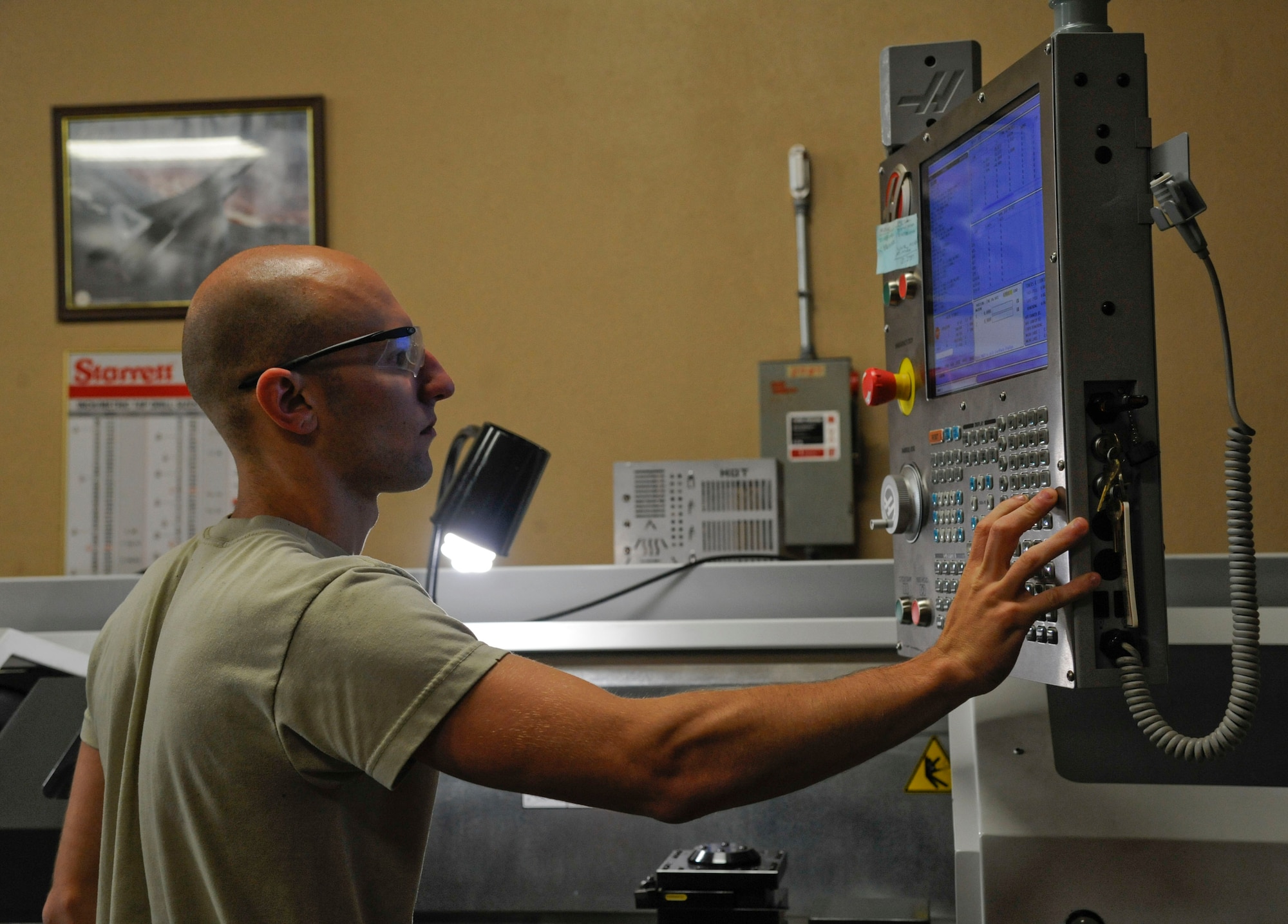 Senior Airman Jared Henden, from the 2nd Maintenance Squadron Fabrication Flight, adjusts the settings on a lathe during the manufacturing of a sniper pod lug on Barksdale Air Force Base, La., June 20, 2013. Metals technology Airmen are capable of creating tools and parts from raw materials. (U.S. Air Force photo/Airman 1st Class Andrew Moua)