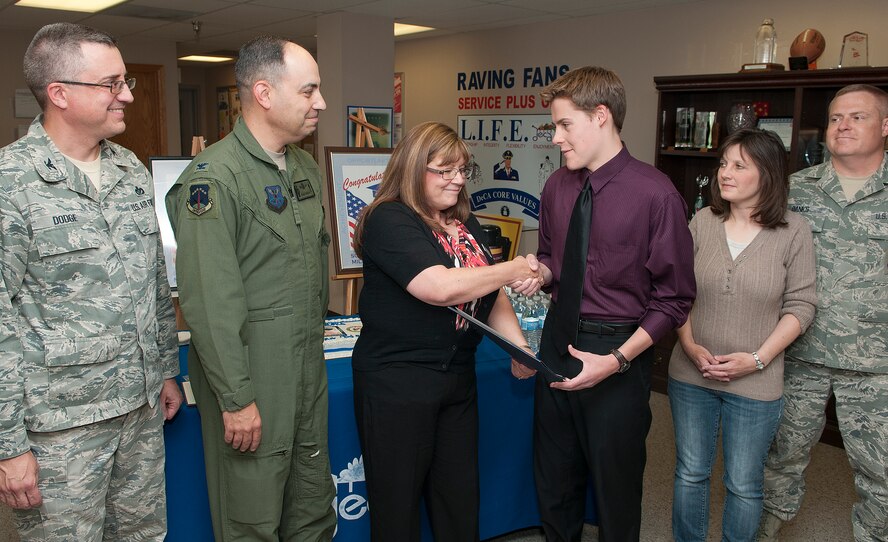 Kathy Beatty, F. E. Warren Commissary store director, presents Jonathan Banks with a college scholarship from Fisher House Foundation as Col. Tim Dodge, 90th Mission Support Group commander; Col. George Farfour, 90th Missile Wing commander; and Jonathan’s parents, Kristie and Chief Master Sgt. Justin Banks, 90th Security Forces Squadron, look on. Abigail Mulcahy was also awarded a scholarship from the Fisher House Foundation, who, according to their website, provides low cost lodging for veterans, service members and their families receiving treatment at military medical centers. (U.S. Air Force photo by R.J. Oriez)