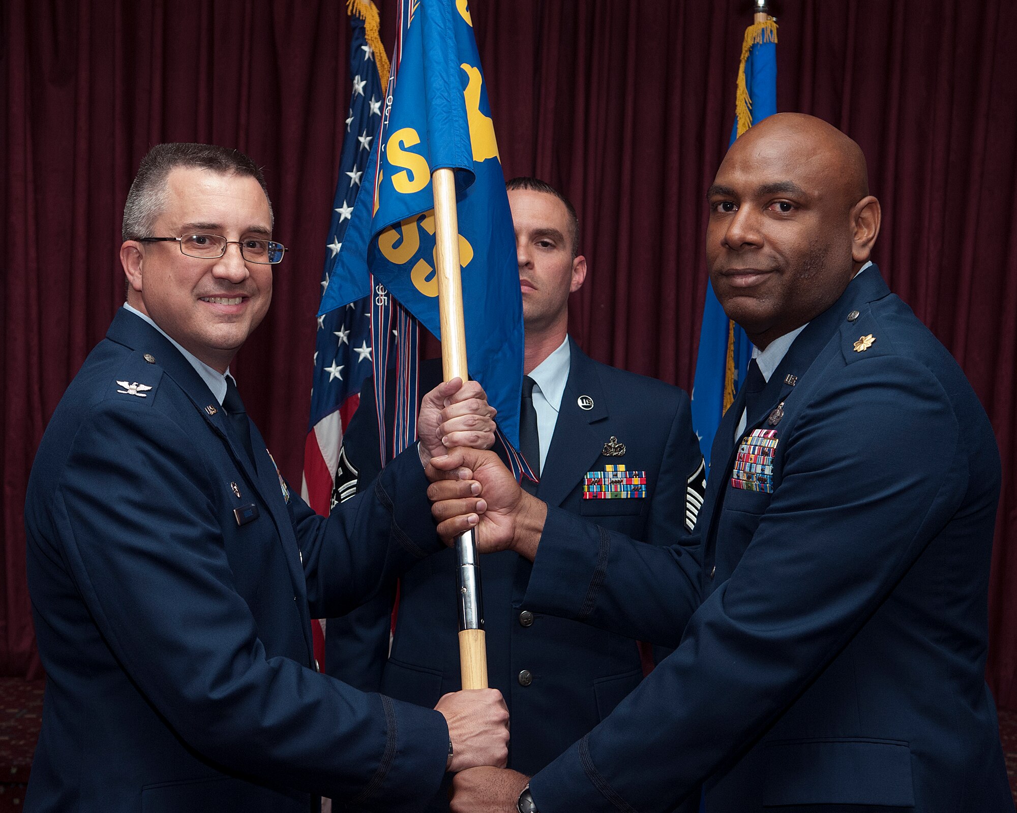 Col. Tim Dodge, 90th Mission Support Group commander, presents the 90th Force Support Squadron guidon to Maj. Dexter Nelson as Nelson assumes command of the squadron June 11, 2013, during a ceremony in the Trail’s End Club on F. E. Warren Air Force Base. (U.S. Air Force photo by R.J. Oriez)