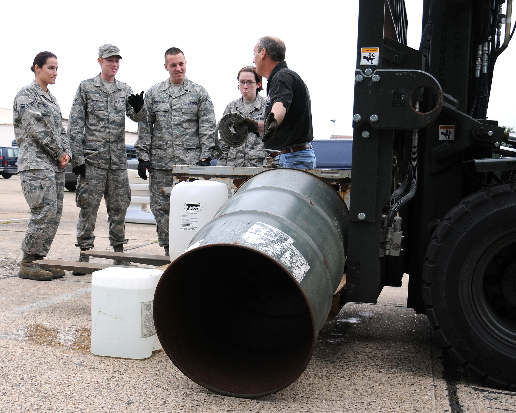 On the right, David Green, 100th Logistics Readiness Squadron Vehicle Operations training manager from Wisbech, Cambridgeshire, demonstrates the results of moving an unsecured load with a forklift during training June 21, 2013, on RAF Mildenhall, England. Commanders of all units performing forklift and materiel handling operations complied with a direction from U.S. Air Forces in Europe to stand-down and conduct safety calls with all personnel to discuss mishaps, evaluate risks and hazards of current and unique forklift and materiel handling equipment operations, analyze the content and effectiveness of training programs and identify shortcomings in guidance. (U.S. Air Force photo by Gina Randall/Released)