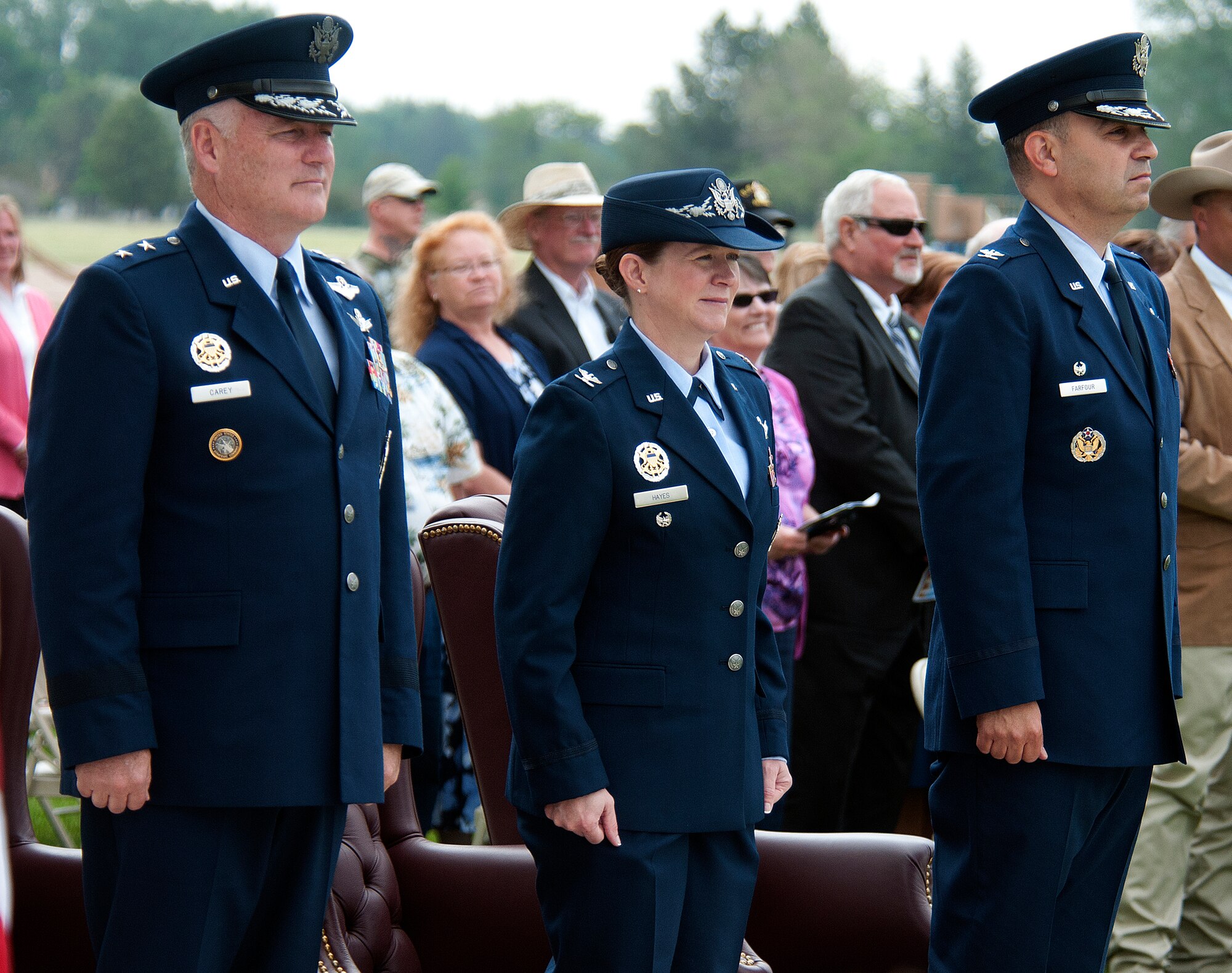 Maj. Gen. Michael Carey, 20th Air Force commander, Col. Tracey Hayes, 90th Missile Wing commander, and Col. George Farfour stand at attention during the playing of the Air Force Song at the end of the 90th MW change-of-command ceremony on F. E. Warren Air Force Base June 17, 2013. During the ceremony, Hayes assumed command of the 90th MW from Farfour. (U.S. Air Force photo by R.J. Oriez)