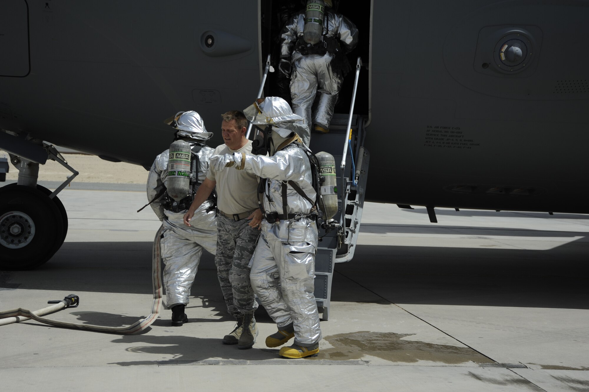 Staff Sgt. Kevin Maxfield, 386th Expeditionary Civil Engineer Squadron firefighter, escorts a “hurt crewmember” to triage during a C-17 Globemaster III aircrew extraction exercise in Southwest Asia, June 17, 2013.  Maxfield is deployed from the 158th Fighter Wing of the Vermont Air National Guard.   (U.S. Air Force photo by Master Sgt. Christopher Campbell)  
