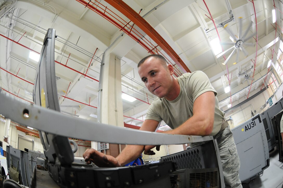 Senior Airman Scott Brown, 36th Aerospace Ground Equipment maintenance technician, references a wiring diagram on a laptop June 19, 2013, on Andersen Air Force Base, Guam. The machine, referred to as a Hobart, provides power without turning on the aircraft engines so aircraft maintainers can work. (U.S. Air Force photo by Airman 1st Class Emily A. Bradley/Released)