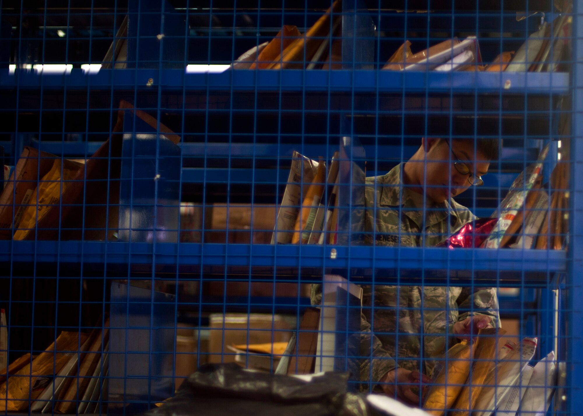 Senior Airman John Meneses, 51st Communications Squadron postal operations clerk, sorts through packages at the Osan Post Office on Osan Air Base, Republic of Korea, June 19, 2013. The team delivers more than three million pounds of mail a year and was recently named the best post office in the Air Force for 2012. (U.S. Air Force photo/Senior Airman Siuta B. Ika)