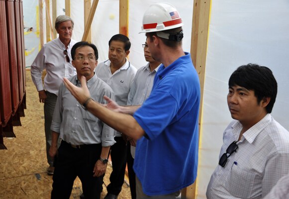 Jamie Holt, wearing helmet, Barkley Power Plant specialist, explains the re-wiring of a hydropower generator rotor to Mekong River Commission members during their June 18, 2013 visit to the Grand Rivers, Ky., project. From left in background, John Emmerson, USACE Pacific Division project manager; Dr. Davong Phonekeo, Lao PDR; Chanthachith Amphaychith, Lao PDR;  Anoulak Kittikhoun, (partially hidden behind Holt) Lao PDR; and Hoang Minh Toan, Vietnam.