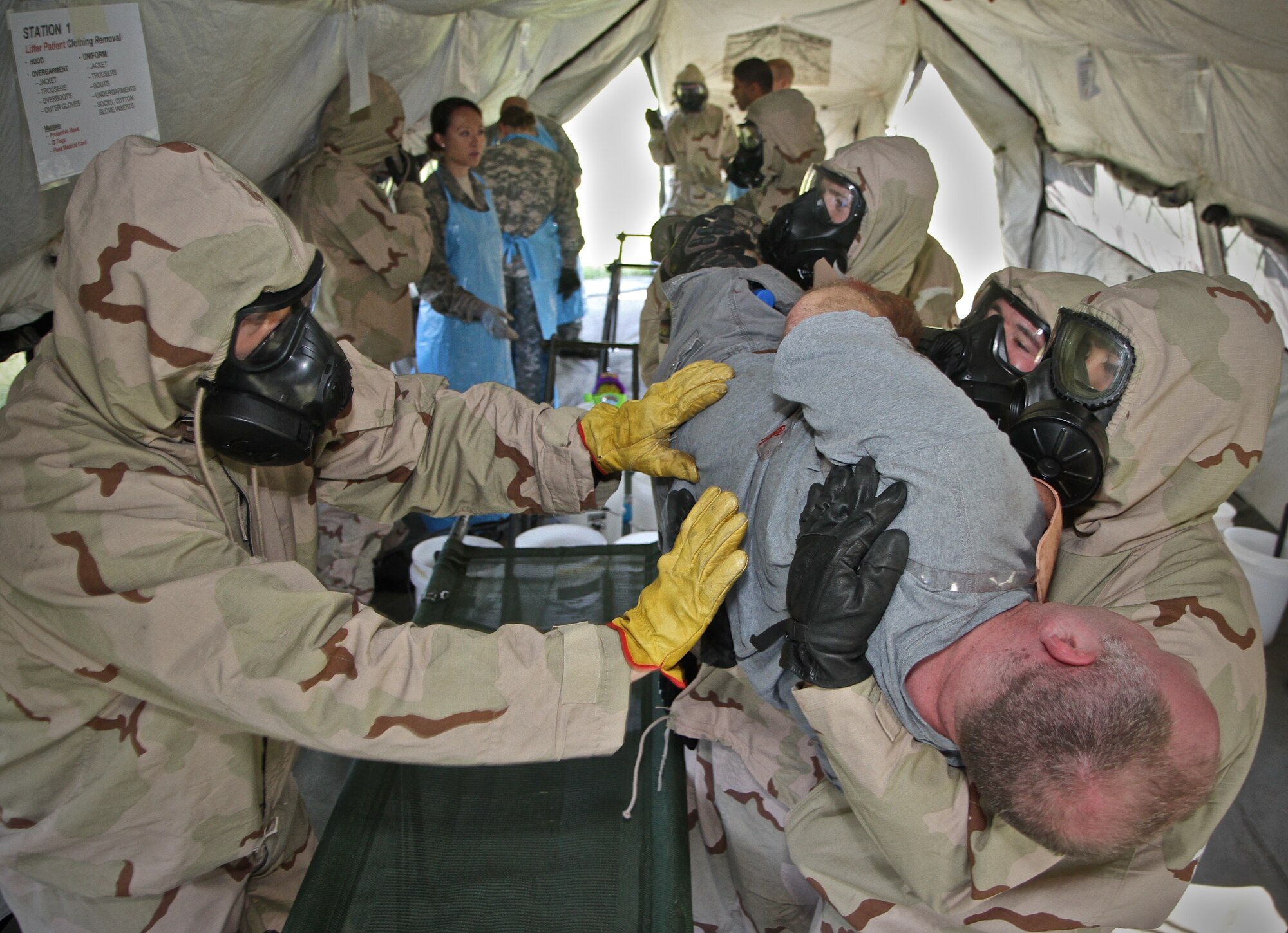 Members of the 932nd Airlift Wing Medical Group work together to decontaminate a volunteer patient during an extensive four-day field exercise at Scott Air Force Base.  The difficult task of cleaning contaminated wounds requires teamwork with coordinated efforts to lift the patient and provide maximum comfort during the process.  (U.S. Air Force photo by Tech. Sgt. Christopher Parr)
