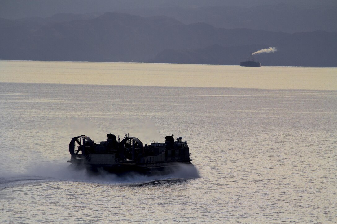 A landing craft, air cushion vessel assigned to the USS Kearsarge (LHD 3) delivers equipment and vehicles to the ship after the conclusion of Exercise Eager Lion, in the gulf of Aqaba, Jordan, June 22, 2013. Exercise Eager Lion 2013 is an annual, multinational exercise designed to strengthen military-to-military relationships and enhance security and stability in the region by responding to modern-day security scenarios. The 26th MEU is a Marine Air-Ground Task Force forawrd-deployed to the U.S. 5th Fleet area of responsibility aboard the Kearsarge Amphibious Ready Group serving as a sea-based, expeditionary crisis response force capable of conducting amphibious operations across the full range of military operations.(U.S. Marine Corps photo by Cpl. Kyle N. Runnels/Released)