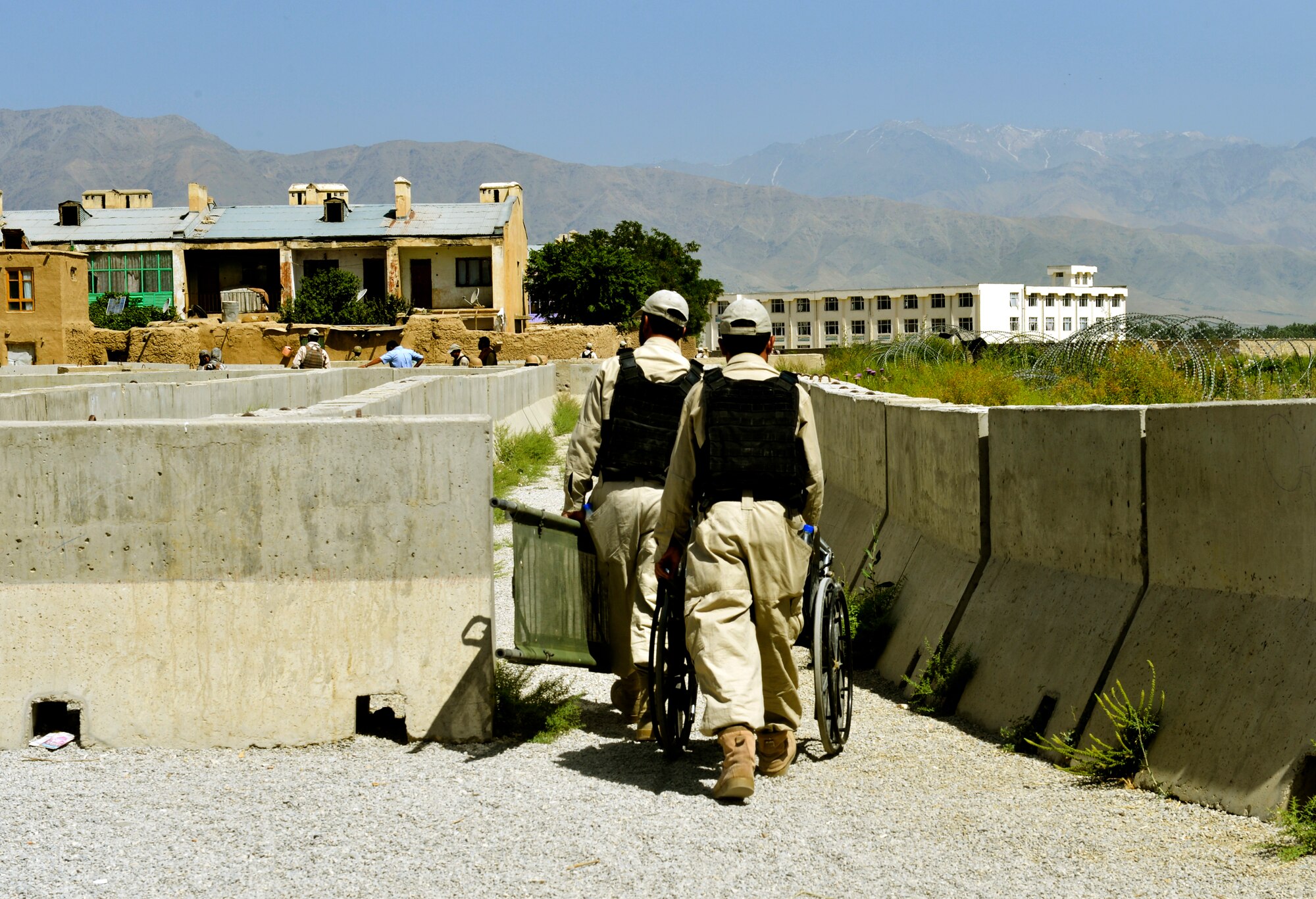 Local Afghans who provide security and searching assistance, take out a gurney and wheel chair to members waiting in line for the Egyptian field hospital to open at Bagram Airfield, Afghanistan, June 22. The field hospital is operated by the Egyptian military, with security provided by Air Force security forces. The field hospital, which opened its door in 2003, today treats more than 7,000 Afghans per month including women and children. (U.S. Air Force photo/ Staff Sgt. Stephenie Wade)