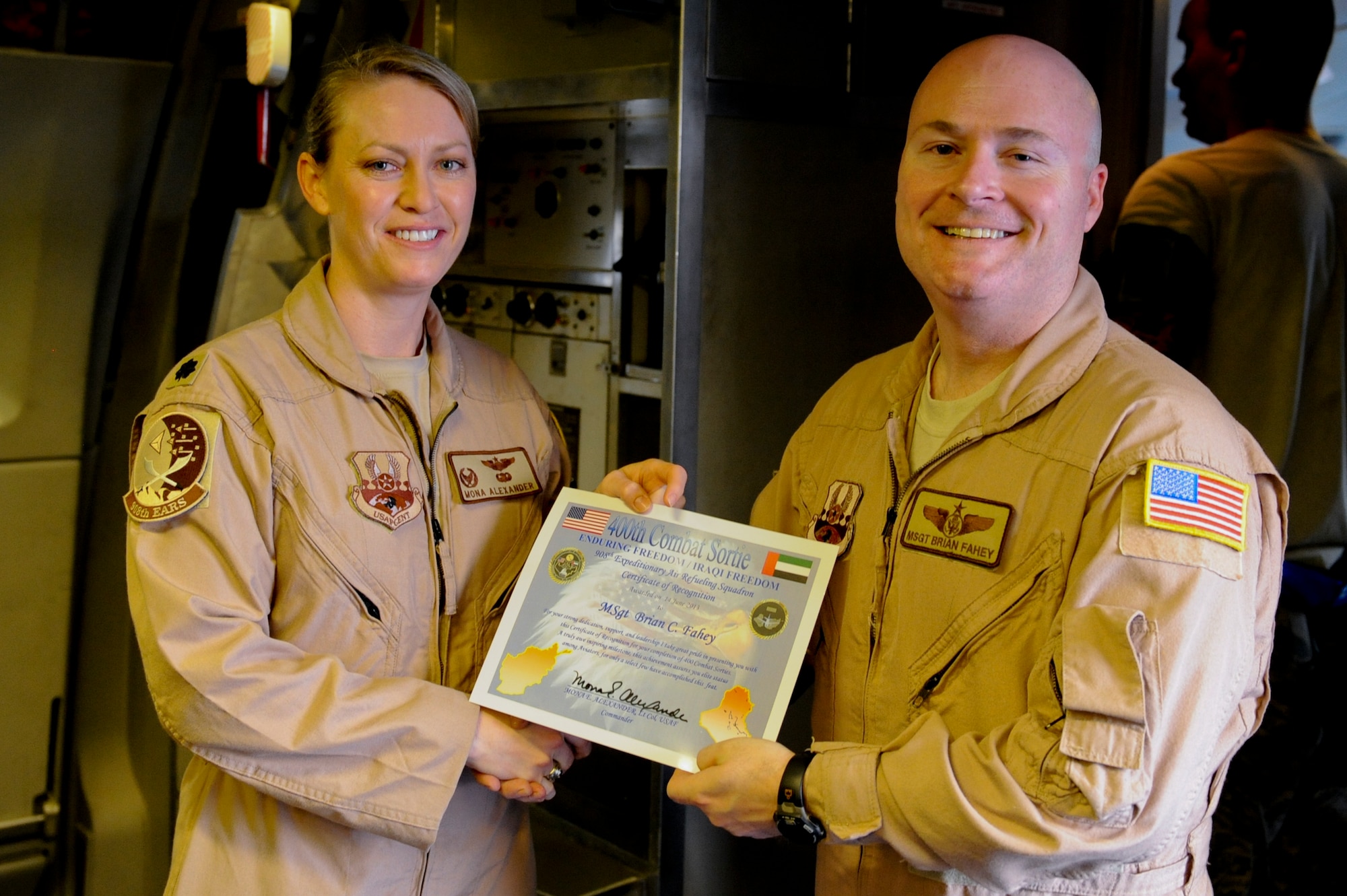 U.S. Air Force Lt. Col. Mona Alexander, 908th Expeditionary Air Refueling Squadron commander, presents U.S. Air Force Master Sgt. Brian Fahey, 908th EARS flight engineer, with a certificate signifying that Fahey had reached 400 combat sorties at an undisclosed location in Southwest Asia June 14, 2013. Fahey accomplished this milestone with 255 missions flown on a KC-10 Extender and 145 missions on a MH-60 Pavelow in support of various operations around the AOR. Alexander is stationed here and is a native of Sun City, Kansas, Fahey hails from Lakewood, N.J., and is deployed from Joint Base McGuire-Dix-Lakehurst, N.J. (U.S. Air Force photo by Staff Sgt. Joshua J. Garcia)  