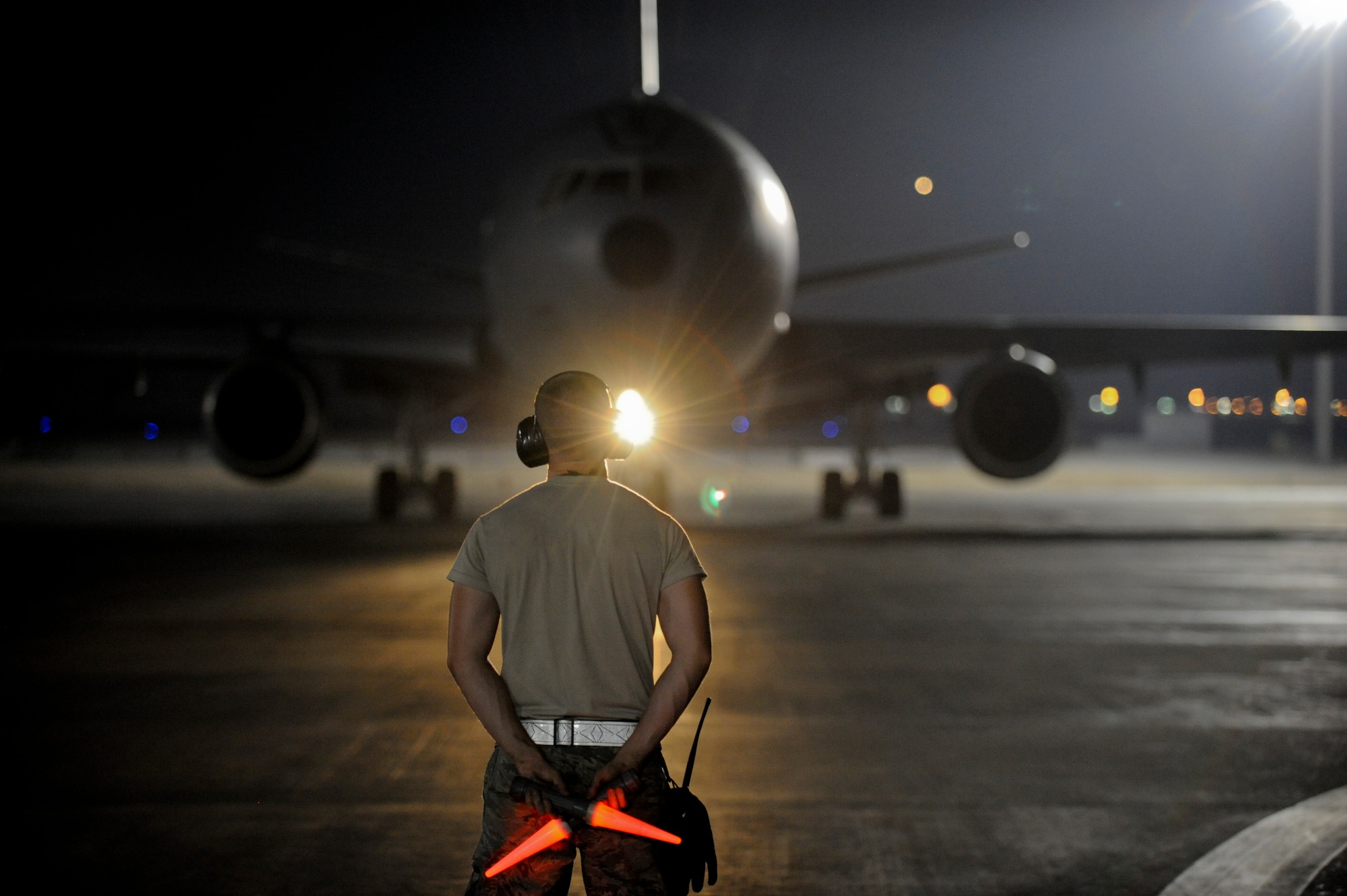 A light from a KC-10 Extender flashes Airman 1st Class Olaf Nelson, 380the Expeditionary Aircraft Maintenance Squadron KC-10 crew chief, signifying the crew is ready for takeoff at an undisclosed location in Southwest Asia June 14, 2013. Nelson is a native of Nazareth, Penn., and is deployed from Joint Base McGuire-Dix-Lakehurst. (U.S. Air Force photo by Staff Sgt. Joshua J. Garcia)  
