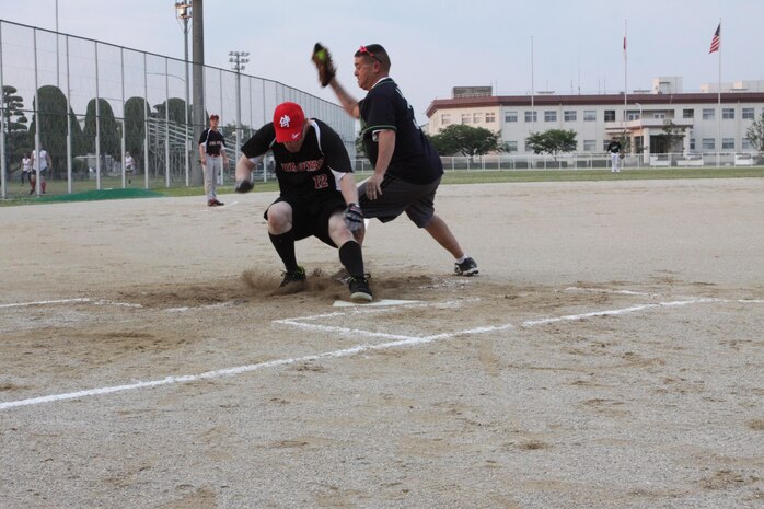 Sgt. Nate K. Ridgely, Marine Aviation Logistics Support Squadron 12 ordnance technician, slides over home plate during a game in the opening week of the Unit Intramural Softball Season June 6, 2013. The regular schedule consists of games Monday through Thursday, June 3 - July 11.
