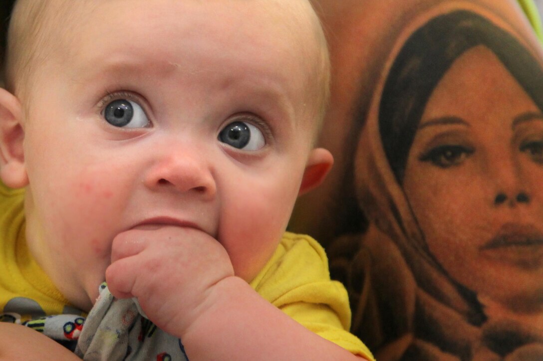 Talon Savoie, 4 months, sits with mom, Shelby, during the 3rd CEB Baby Shower. The unit held a battalion-wide baby shower for the 36 pregnant and recently pregnant spouses while the unit is deployed to Afghanistan.
