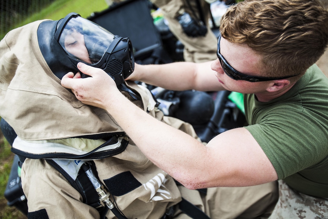 Lance Cpl. Dylan Shuler, 22nd Marine Expeditionary Unit chemical, biological, radiological and nuclear defense specialist and native of Bell Buckle, Tenn., helps Lance Cpl. Jarrod Roper, 22nd MEU CBRN specialist and native of Villa Rica, Ga., don his level "B" protective suit as the Marines prepare to search a subway for casualties and an unknown chemical or biological agent during hazardous material response training at the Guardian Centers in Perry, Ga., June 21, 2013. Split among a reconnaissance and sampling team, the Marines searched for casualties, marking them with glow sticks for later rescue, located the chemical agent responsible for the simulated incident and sampled it to determine what it was and how to best eliminate the threat and treat the casualties. Eleven CBRN Marines attended the weeklong course, which was custom-tailored to the needs of the 22nd MEU and follows the CBRN Marines’ technical rescue training at the end of May. (Marine Corps photo by Sgt. Austin Hazard/Released)