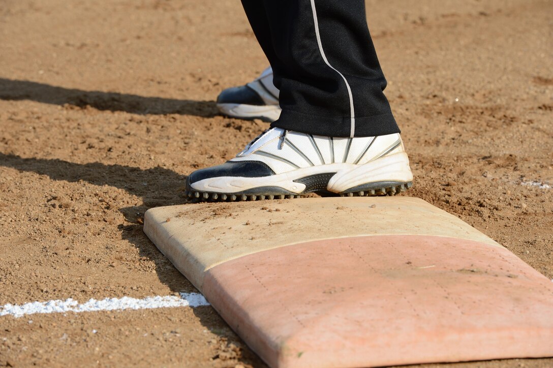 Brennan Kriner, Officer Candidates School team Extra Hitters left center, keeps one foot planted on first base as he prepares to run to second during the intramural softball season opener on Marine Corps Base Quantico June 17, 2013, at the Field of Dreams 1 and 2. OCS beat the Legal Services Support Section; 18-3.