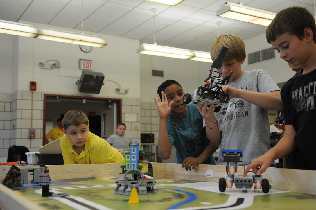 From left, rising seventh-grader Mackenzie looks on as his classmates, Joseph and Chip, work on their team’s LEGO robot and rising eighth-grader Matthew tests his team’s robot on the morning of June 21, 2013, at Quantico Middle/High School’s weeklong Science, Technology, Engineering and Math Academy. 