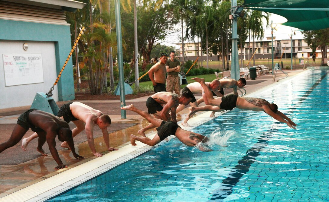 Corporals Course students jump into a pool during a physical training session, here, June 21. The course provides corporals with the education and skills necessary to lead Marines. Two Australian soldiers and a Navy corpsman enrolled in the course to further their Marine Corps knowledge.
