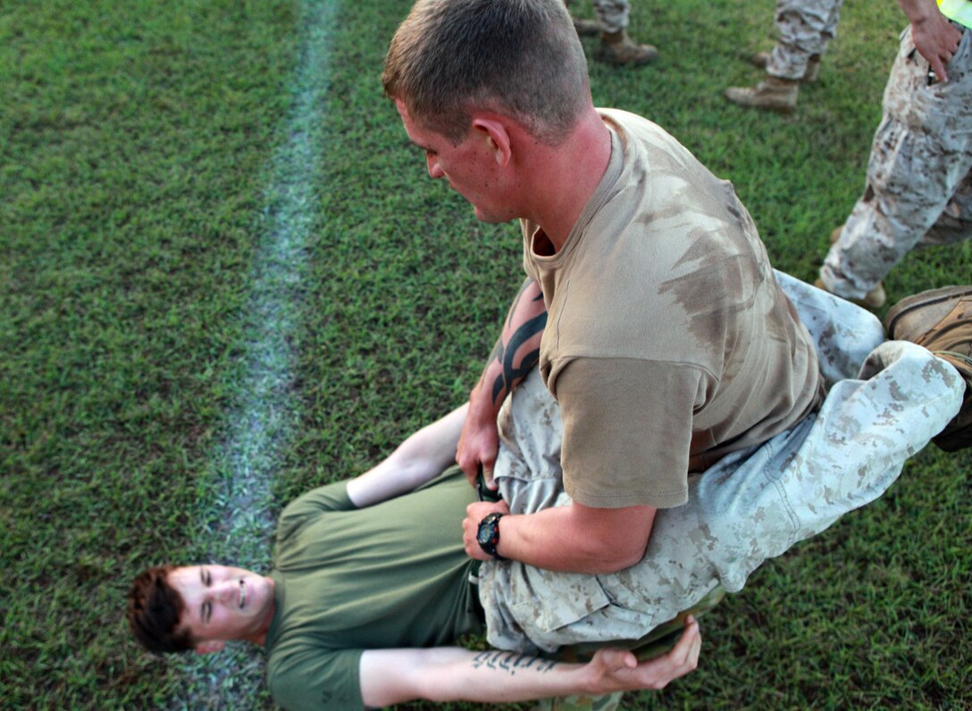 Australian Army Pvt. David Druely, rifleman, Charlie Company, 5th Battalion, Royal Australian Regiment, holds Cpl. Richard Kripps, team leader, 1st Platoon, Lima Company, 3rd Battalion, 3rd Marine Regiment, Marine Rotational Force - Darwin, as he conducts hanging-guard sit ups during a Corporals Course physical training session, here, June 18. The course provides corporals with the education and skills necessary to lead Marines. Two Australian soldiers and a Navy corpsman enrolled in the course to further their Marine Corps knowledge.