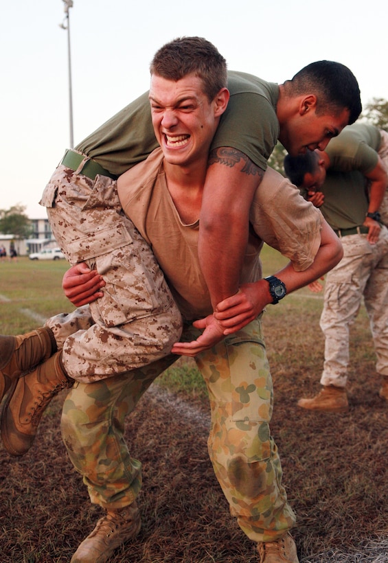 Australian Army Pvt. Scott Bailed, riflemaan, Charlie Company, 5th Battalion, Royal Australian Regiment, completes a buddy squat exercise with Cpl. Oziel Esquivel, data supervisor, Headquarters Platoon, Lima Company, 3rd Battalion, 3rd Marine Regiment, Marine Rotational Force - Darwin, during a Corporals Course physical training session, here, June 18. The course provides corporals with the education and skills necessary to lead Marines. Two Australian soldiers and a Navy corpsman enrolled in the course to further their Marine Corps knowledge.