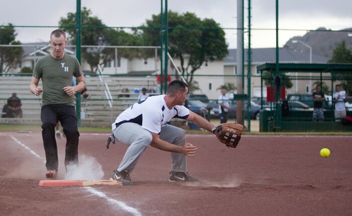 Marine Heavy Helicopter Squadron 463 outfielder Jessy Longan sprints to first base as Headquarters Battalion first baseman Terry Brayer attempts to catch the ball during an intramural softball game at Annex Field, June 13. Pegasus defeated Headquarters Bn. with a final score of 18-6. (U.S. Marine Corps photo by Lance Cpl. Suzanna Lapi)