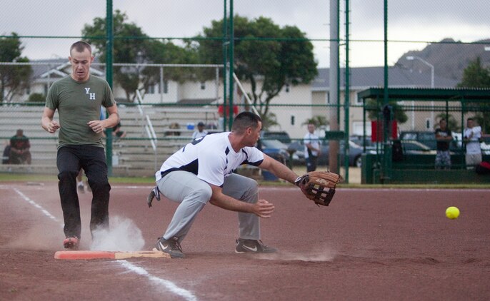 Marine Heavy Helicopter Squadron 463 outfielder Jessy Longan sprints to first base as Headquarters Battalion first baseman Terry Brayer attempts to catch the ball during an intramural softball game at Annex Field, June 13. Pegasus defeated Headquarters Bn. with a final score of 18-6. (U.S. Marine Corps photo by Lance Cpl. Suzanna Lapi)