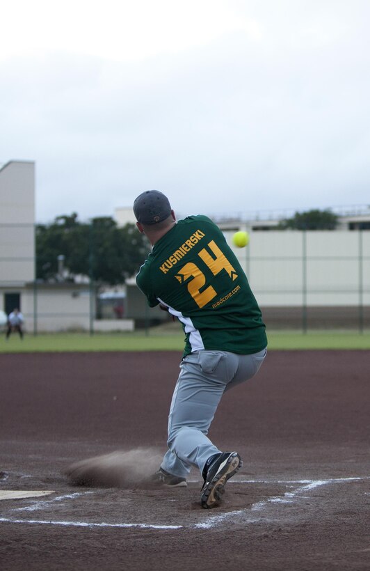 Marine Heavy Helicopter Squadron 463 left center Anthony Kusmierski hits the ball during an intramural softball game against Headquarters Battalion at Annex Field, June 13, 2013. (U.S. Marine Corps photo by Lance Cpl. Suzanna Lapi)