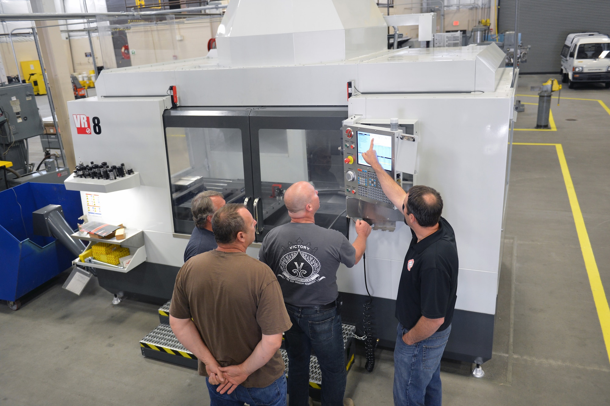Civilian personnel from the 62nd Maintenance Squadron fabrication flight metals technology section train on how to operate a 5-axis machining center used for milling and drilling metal June 17, 2013 at Joint Base Lewis-McChord, Wash. Metals technology is responsible for manufacturing and repairing replacement or repair parts and hardware for C-17 Globemaster III aircraft at JBLM. (U.S. Air Force photo/Airman 1st Class Jacob Jimenez)