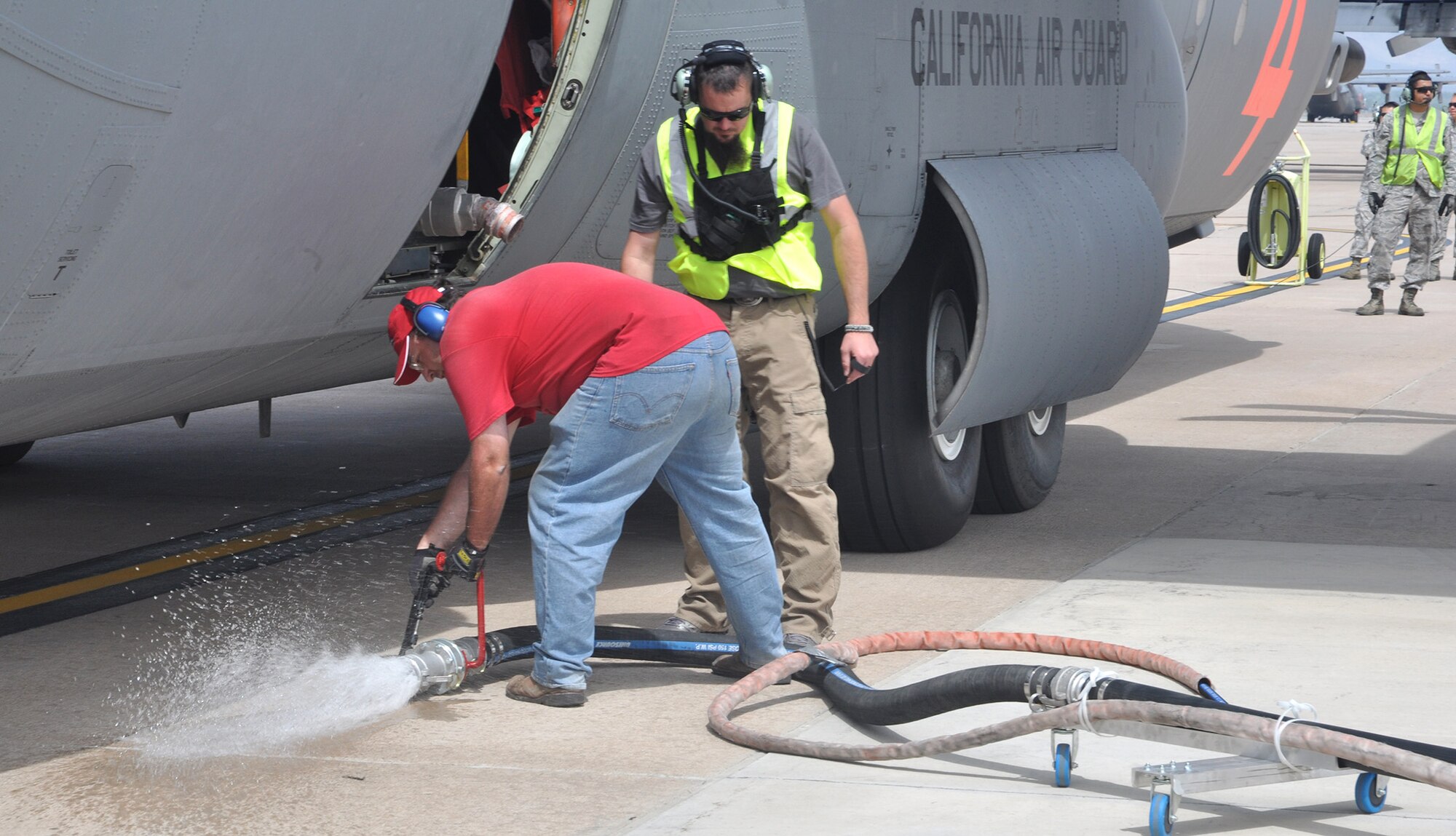 An air tanker "pit" crew detaches a fire retardant loading hose from a California Air National Guard C-130 June 24 prior to the aircraft's departure from Peterson Air Force Base, Colo. Portions of Peterson AFB's flightline were converted into an air tanker base for aerial firefighting operations the same day, providing additional capabilities to both military and civilian air tankers. The aircraft is assigned to the 146th Airlift Wing, based in Channel Islands, Calif. (U.S. Air Force photo/Tech. Sgt. Stephen J. Collier)