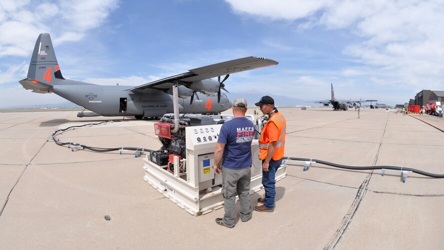 An air tanker "pit" crew prepares a fire retardant compressor for operation June 24 as Air Force C-130s prepare to depart Peterson Air Force Base, Colo. Portions of Peterson AFB's flightline were converted into an air tanker base for aerial firefighting operations the same day, providing additional capabilities to both military and civilian air tankers. Aircraft from both the California Air National Guard (center) and the Air Force Reserve (right) are featured. (U.S. Air Force photo/Tech. Sgt. Stephen J. Collier)