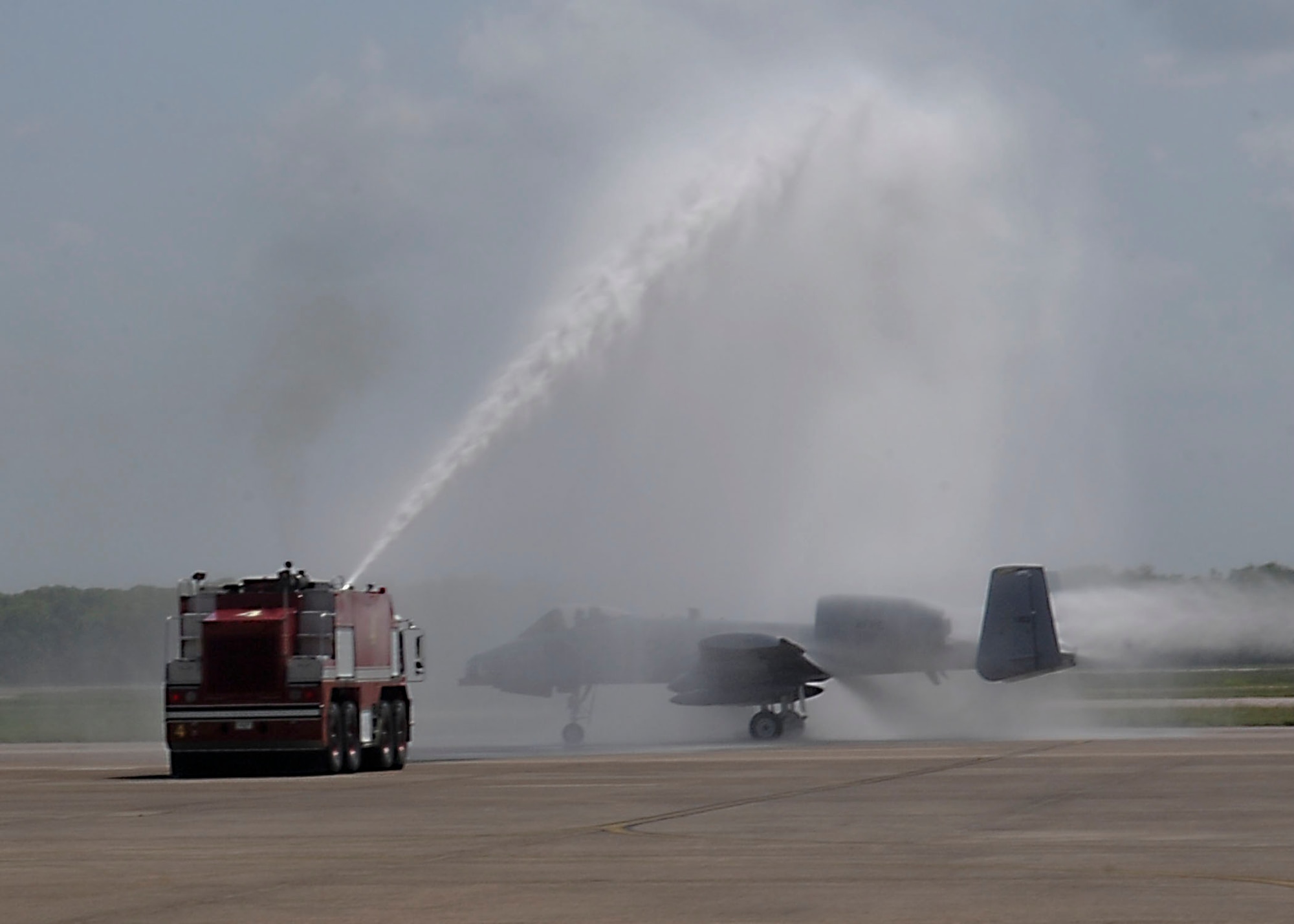 Firetrucks spray an A-10 Thunderbolt II attack aircraft during its final flight on Barksdale Air Force Base, La., June 24, 2013. Members of the community and Barksdale Airmen bid farewell to the A-10 after 33 years on base. (U.S. Air Force photo)(Senior Airman Kristin High)
