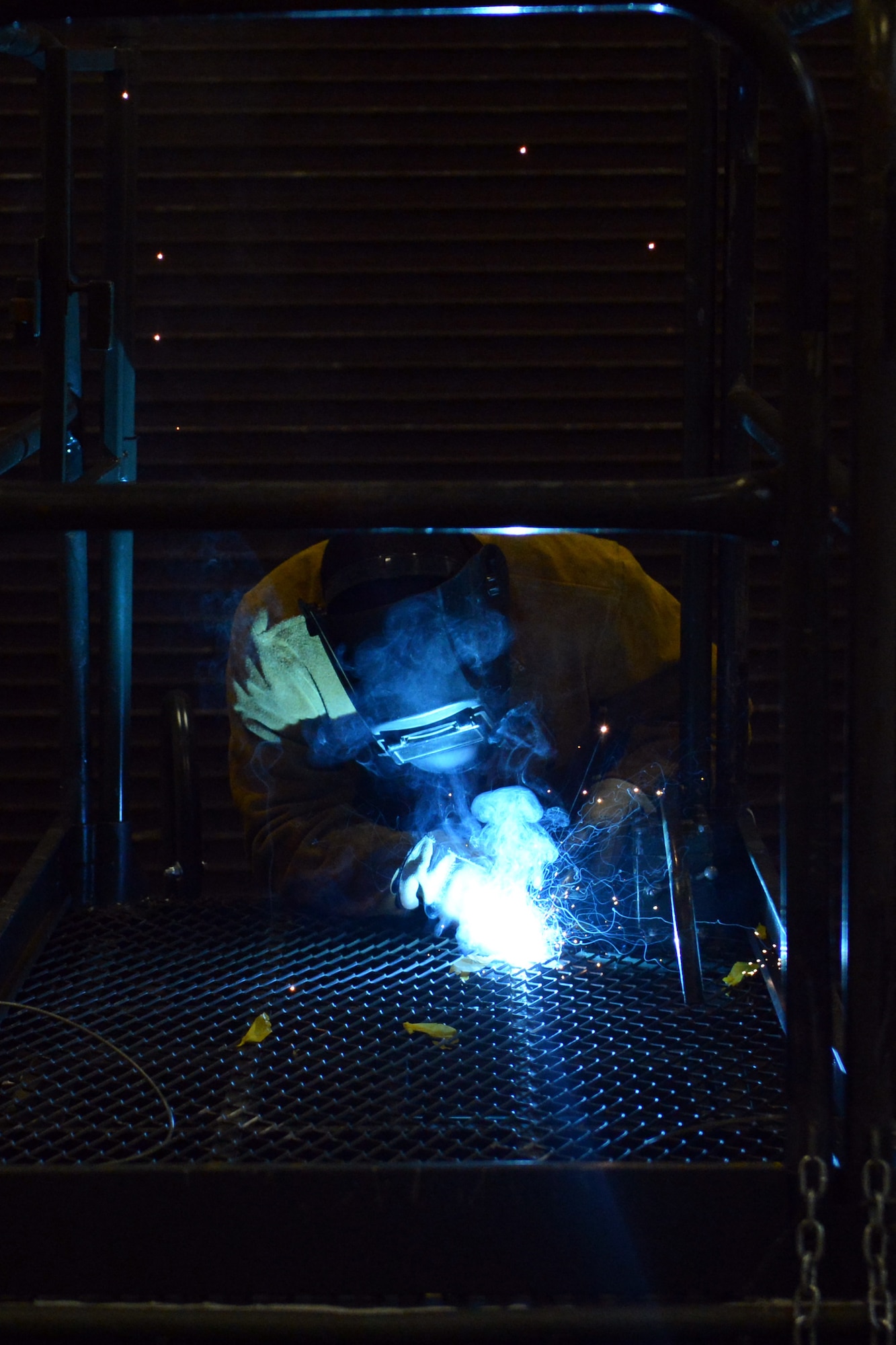 Airman 1st Class Angel Laureano Pinero, 62nd Maintenance Squadron metals technology apprentice, welds a cracked floor panel of a lift used to make repairs to C-17 Globemaster III aircraft June 17, 2013 at Joint Base Lewis-McChord, Wash. (U.S. Air Force photo/Airman 1st Class Jacob Jimenez)