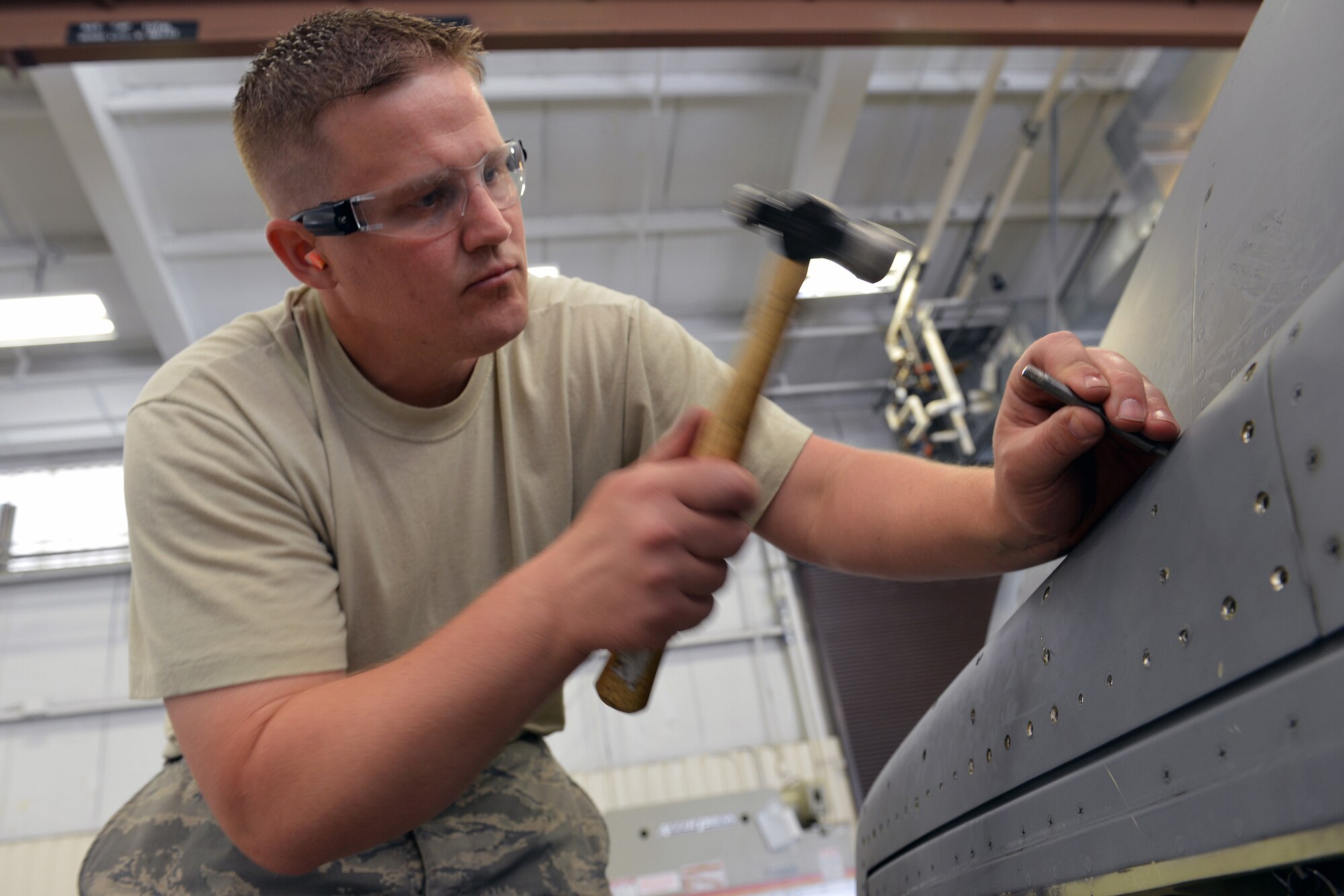 Staff Sgt. Tobias Abernathy, 62nd Maintenance Squadron structural maintenance technician, hammers rivets out from a thrust reverser to repair a cracked surface May 13, 2013 at Joint Base Lewis-McChord, Wash. The aircraft structural maintenance section of the fabrication flight, often referred to as the sheet metal shop, is responsible for creating composite materials, fabricating metals and applying paint to C-17 Globemaster III aircraft stationed at JBLM. (U.S. Air Force photo/Airman 1st Class Jacob Jimenez)