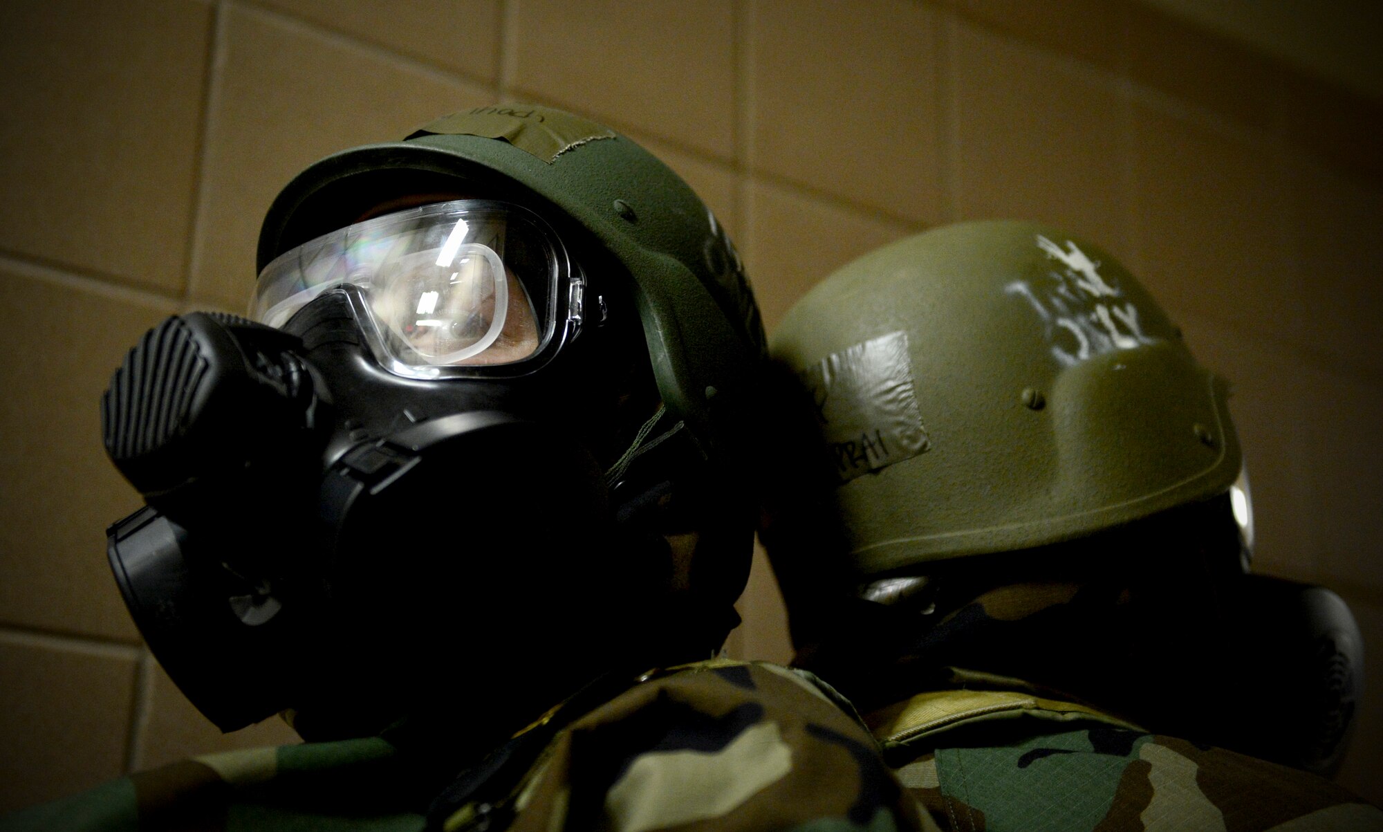 Senior Airman Mary Thach, a photojournalist with the Nebraska Air National Guard’s 155th Air Refueling Wing, and Senior Airman Bristol Prai, a video broadcaster with the 155th ARW, rest against one another in full chemical suits as they participate in the Ability to Survive and Operate exercise at the Nebraska National Guard air base in Lincoln, Neb., June 11, 2013. Members of the 155th ARW participated in the ATSO to evaluate and improve their capabilities and skills in a wartime scenario. (U.S. Air National Guard photo by Staff Sgt. James Lieth/Released)