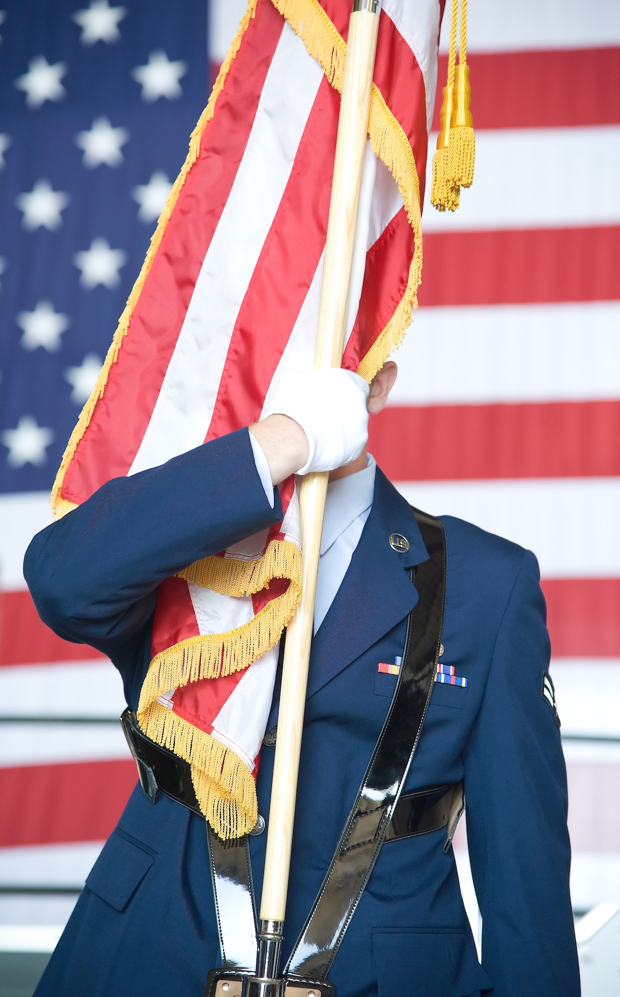 Airman 1st Class Stephen L. Peters holds the American flag which obscures most of this face as the National Anthem is sung during the opening ceremony for the Change of Command for the 436th Maintenance Group on June 20th, 2013 at Dover Air Force Base, Del. Col. Thomas J. Kauth relinquised command to Col. Charles S. Nesemeier in a ceremony officiated by Col. Richard Moore, 436th Airlift Wing commander. (U.S. Air Force photo/Greg L. Davis) 