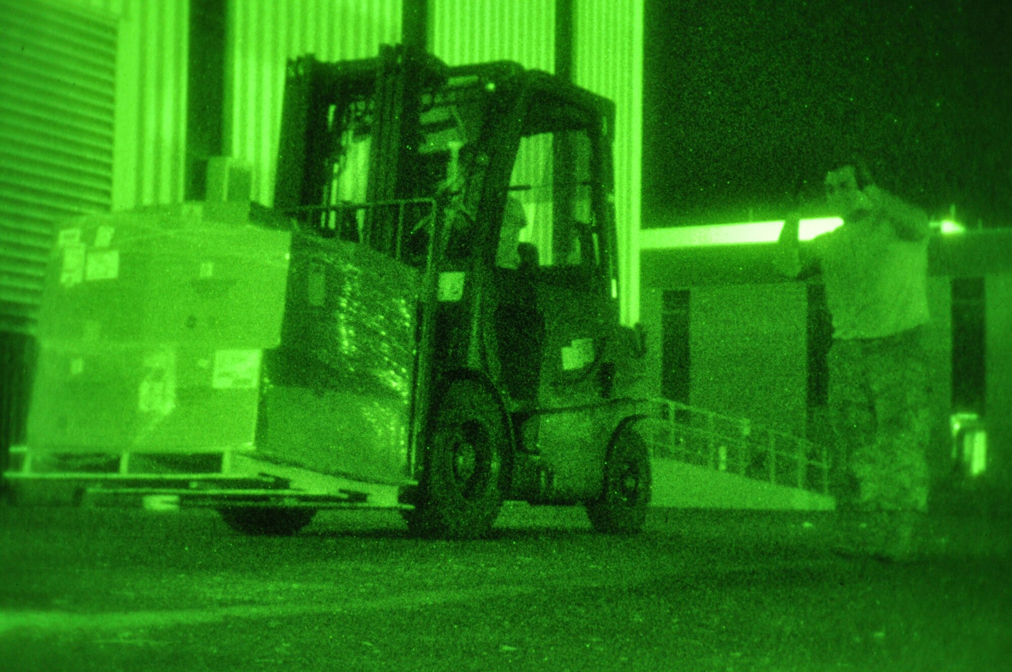 Senior Airman Mo Padilla, 60th Aerial Port Squadron porter, marshals Airman 1st Class Taylor Still, 60th APS porter, as he maneuvers a forklift carrying cargo Tuesday at the cargo warehouse. (U.S. AIr Force photo/Staff Sgt. Patrick Harrower)