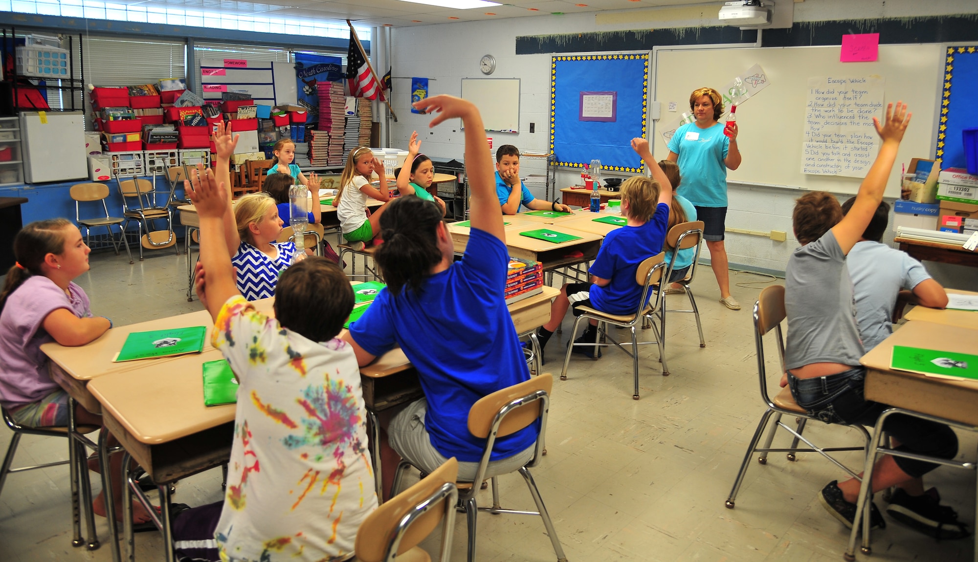 Children raise their hands while answering questions about air during the Science and Technology Academies Reinforcing Basic Aviation and Space Exploration (STARBASE) Program at Meadow Lane Elementary School in Goldsboro, N.C., June 18, 2013. STARBASE is a five-day camp which aims to teach fifth graders about math and science. (U.S. Air Force photo by Senior Airman Aubrey White/Released)