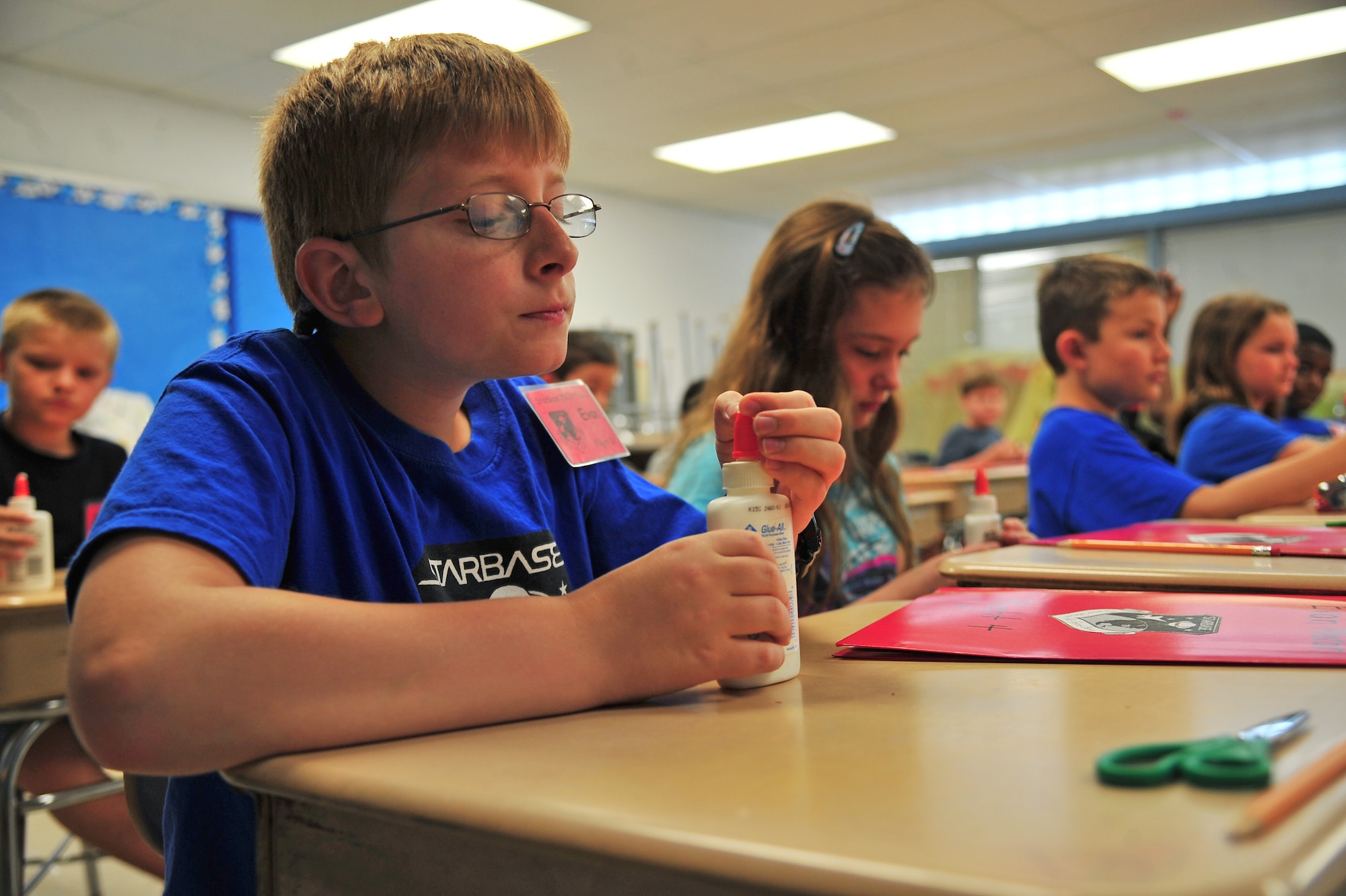Son of U.S. Air Force Col. Brent Moran, 4th Mission Support Group commander, opens a bottle of glue during the Science and Technology Academies Reinforcing Basic Aviation and Space Exploration (STARBASE) Program at Meadow Lane Elementary School in Goldsboro, N.C., June 18, 2013. STARBASE is a five-day camp which aims to teach fifth graders about math and science. (U.S. Air Force photo by Senior Airman Aubrey White/Released)
