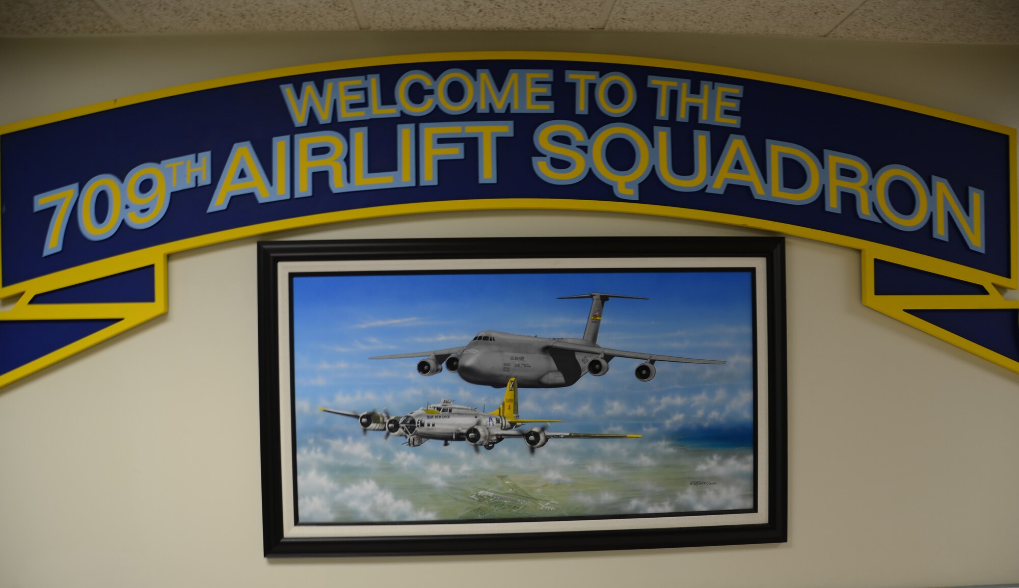 Pictured at the entrance of the 709th Airlift Squadron, Dover Air Force Base, Del., is a piece of art depicting a B-17 named "Blue Hen Chick" with a C-5B named "Spirit of the Blue Hen." The Reserve unit has flown both of these aircraft and will continue flying the Blue Hen legacy following the delivery of Dover's 11th C-5M named "Spirit of the Blue Hen," June 21, 2013. (U.S. Air Force photo/Master Sgt. Veronica Aceveda)