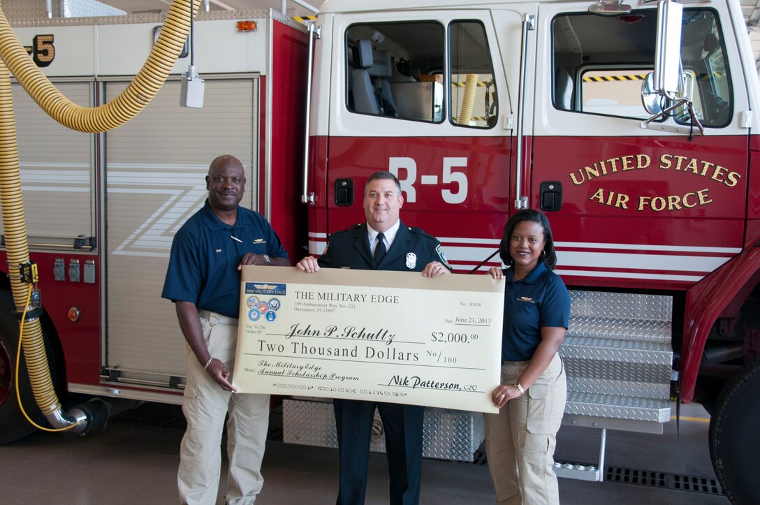 Fire Inspector John Schultz is presented with a $2,000 scholarship June 21, by The Military Edge, a small business that supports active military members and veterans with education and employment opportunities. “All we want to say to the veterans is thank you for your service, and there are resources out there that you can use,” said Pat Patterson director of marketing for The Military Edge. “We are here to help link you to whatever you need.” (U.S. Air Force photo by Tech. Sgt. Andrew Caya.)

