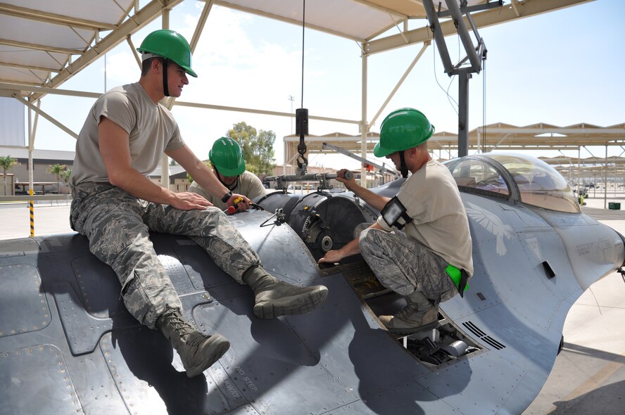 Air Force Academy Cadet 2nd Class Joshua Burdge, left, installs a 20mm gun drum on an F-16 June 14 on the flightline. The cadets spent the day shadowing armament systems specialists from the 308th Aircraft Maintenance Unit. The cadets also visited the medical group, public affairs, finance and security forces. The cadets were participating in Operation Air Force, a program designed to give cadets operational Air Force experience before graduation. (U.S. Air Force photo/Staff Sgt. Luther Mitchell Jr.)