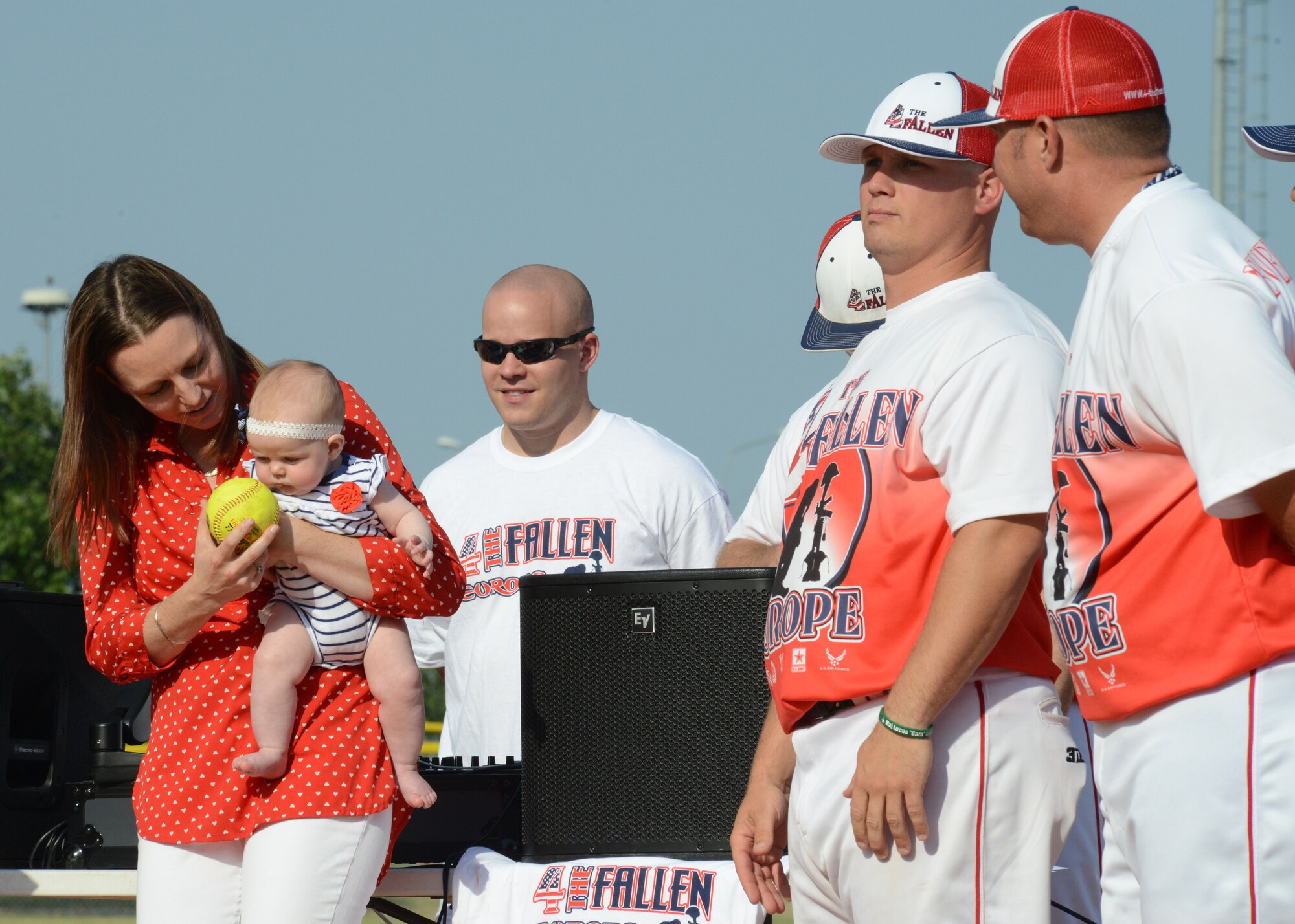 Cassy Gruenther jokingly offers a softball to her daughter, Serene, to throw the opening day pitch during a softball tournament June 21, 2013, at Aviano Air Base, Italy. The round-robin softball tournament was dedicated to the life of Maj. Lucas Gruenther; a fighter pilot assigned 31st Fighter Wing, who crashed during a training mission over the Adriatic Sea Jan. 28, 2013. (U.S. Air Force photo/Airman Ryan Conroy) 