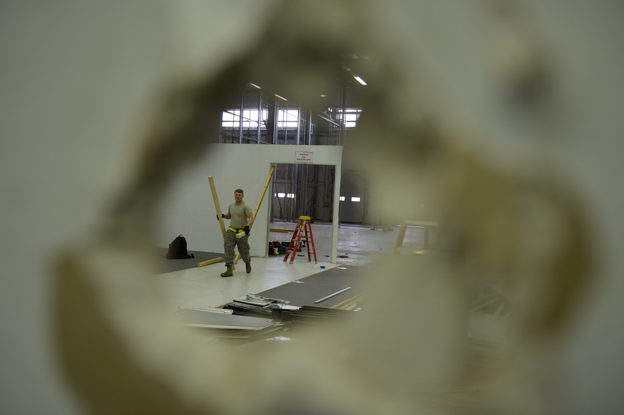 BITBURG ANNEX, Germany -- U.S. Air Force Airman 1st Class Garth Page, 52nd Civil Engineer Squadron structural technician from Sacramento, Calif., moves wooden beams during construction at the new gymnastics gym location April 11, 2013. Nearly 60 Saber volunteers helped with the installation and movement of equipment into the new facility. (U.S. Air Force photo by Airman 1st Class Gustavo Castillo/Released)