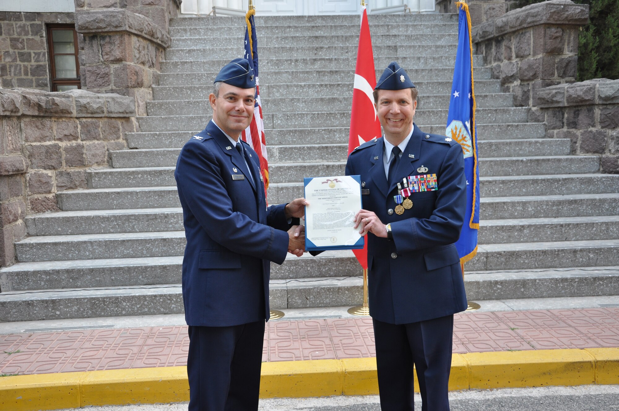 Col. Sean Gallagher, 39th Mission Support Group commander, gives Lt. Col. Marc Galler, outgoing 425th Air Base Squadron commander, his Meritorious Service Medal during a change of command ceremony June 13, 2013. Gallagher served as the presiding officer in the ceremony. (Photo by Tanju Varlikli)
