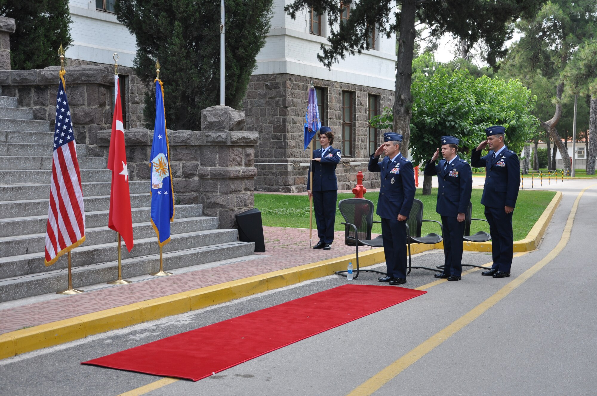 Col. Sean Gallagher, 39th Mission Support Group commander, Lt. Col. Marc Galler, outgoing 425th Air Base Squadron commander, and Lt. Col. Gary Goosen, incoming 425th ABS commander, salute the flags during the playing of the Turkish and U.S. national anthems at the 425th ABS change of command ceremony June 13, 2013. (Photo by Tanju Varlikli)
