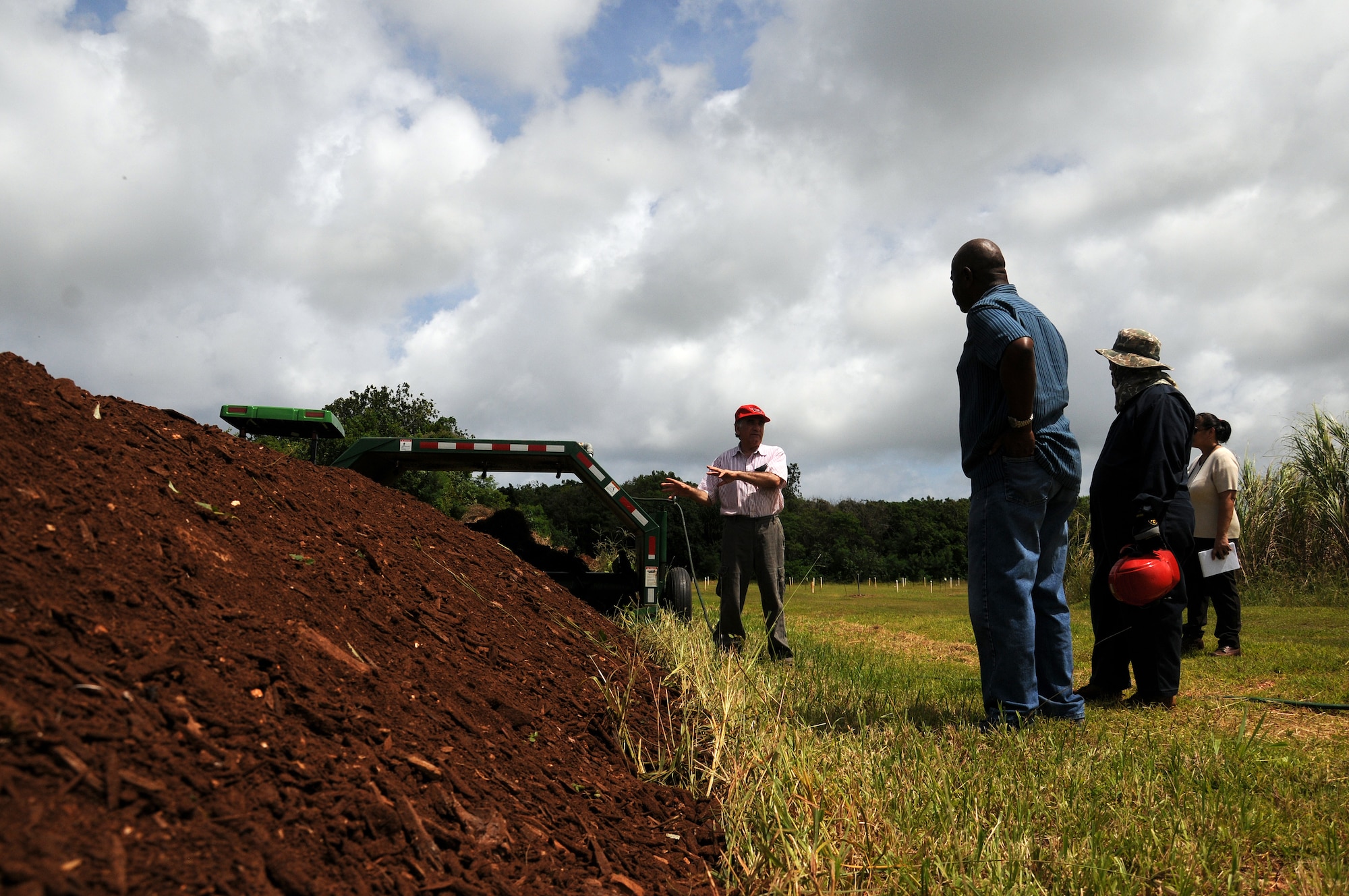 Mohammad Golabi, University of Guam associate professor of soil and environmental sciences, explains how he uses mulch provided by Andersen Air Force Base, Guam, for a composting experiment at the UOG Research Farm in Yigo, Guam, June 19, 2013. The professor, technicians and students collected nearly 250 cubic yards of mulch from Andersen AFB throughout the year for a project that will benefit the local agriculture community. (U.S. Air Force photo by Staff Sgt. Melissa B. White/Released)