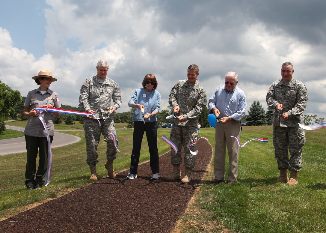 (l to r) Raystown Ranger Tara Whitsel holds the ribbon as Maj. Gen. Michael J. Walsh, Corps Deputy Commander for Civil Works and Emergency Operations; Ms. Jo-Ellen Darcy, Assistant Secretary of the Army for Civil Works; Brig. Gen. Kent Savre, North Atlantic Division commander; Dan Hawbaker, President and CEO of Glenn O. Hawbaker Inc. and Lt. Col. Brad Endres, District Deputy Commander cut a ribbon officially opening the Greenside Pathway at Raystown Lake, June 20.